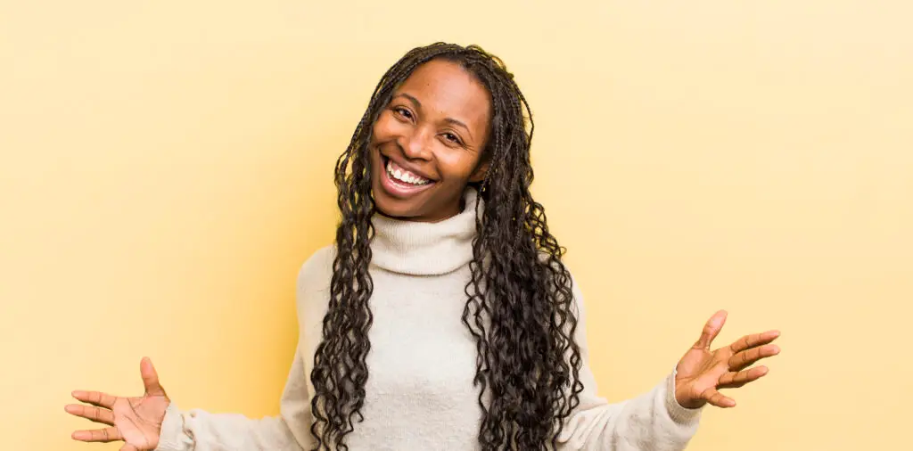 Black woman with long hair smiling and hold hands out and open