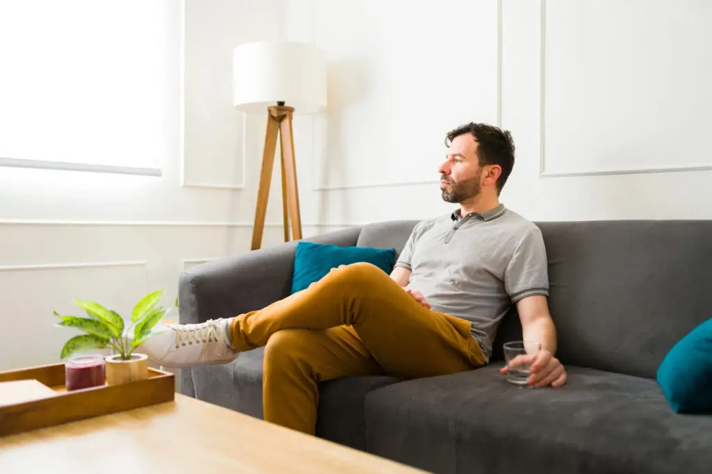 Man sitting on couch thinking