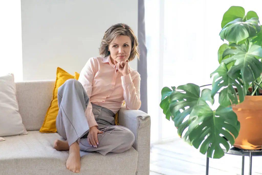 Woman sitting on couch thinking